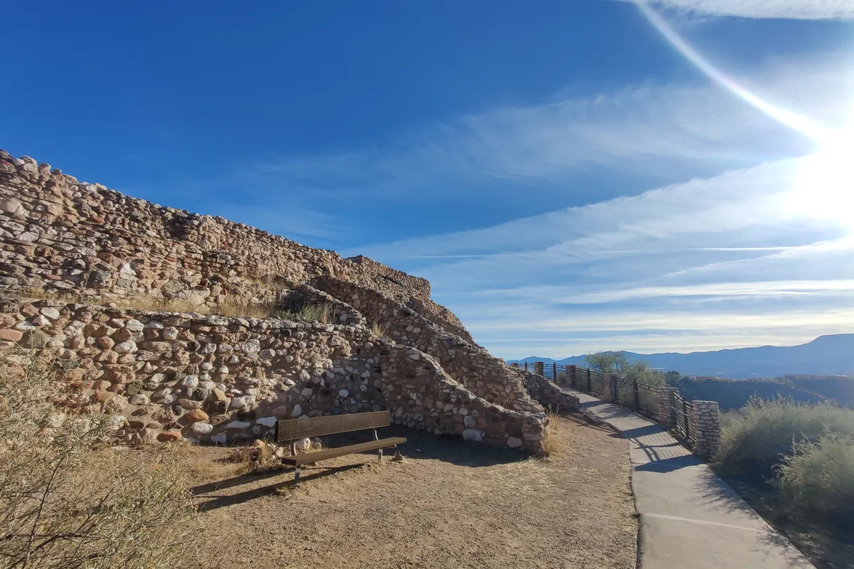 The stone ruins of the Tuzigoot hilltop pueblo under a blue sky