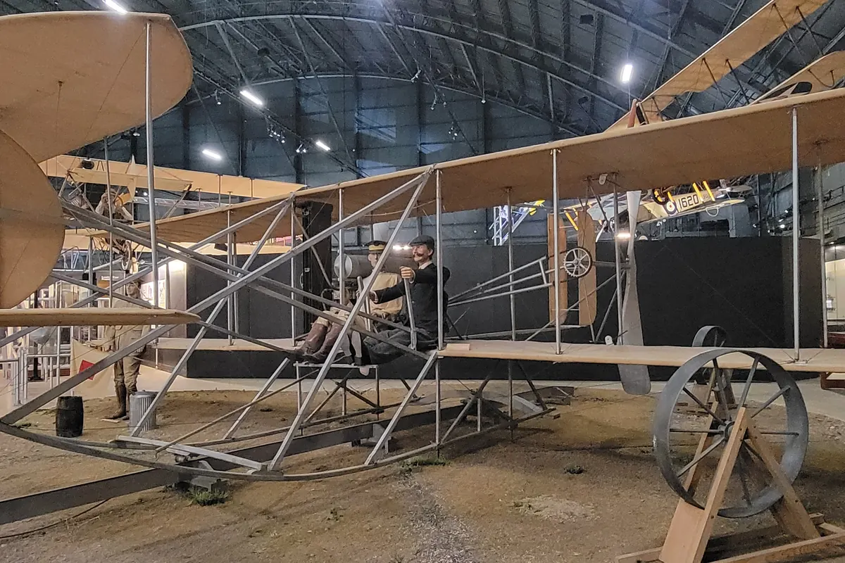 An early Wright-style biplane on display inside a museum hangar