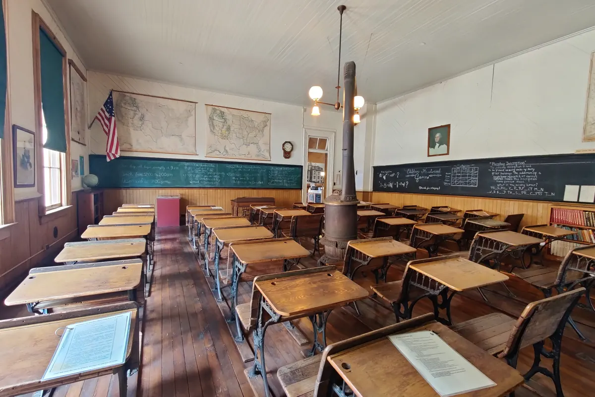 A classroom with rows of wooden desks inside the Fourth Ward School in Virginia City